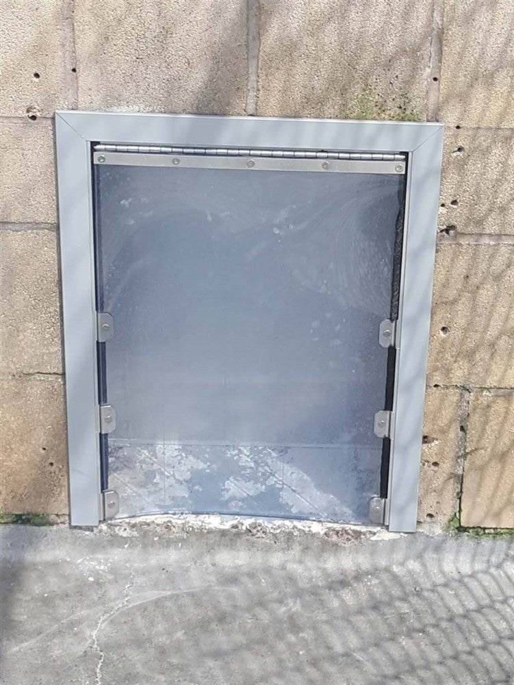 Porte chenil extérieure 3 côtés posée dans un mur crépi de chenil